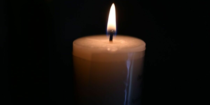 A burning candle with a black background